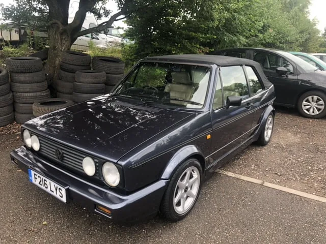 A Volkswagen Golf Cabriolet outside the garage