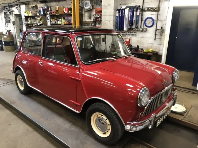 A red Mini on the ramp in the workshop